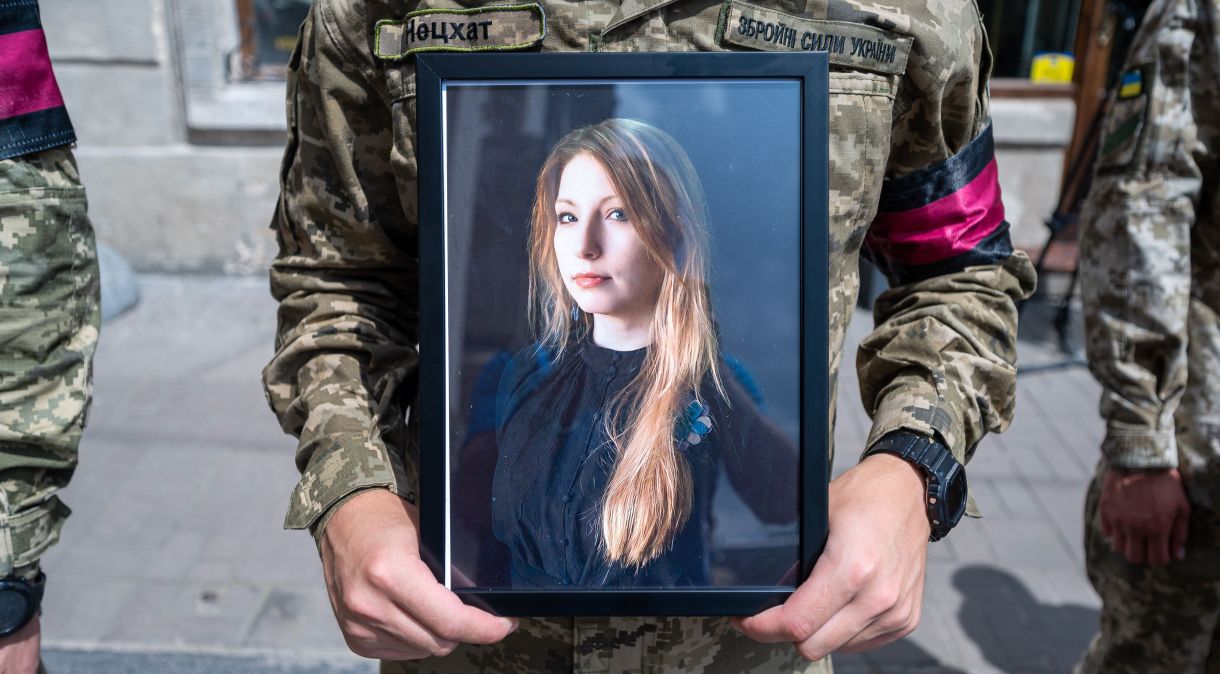 Soldado ucraniano segura foto da escritora Victoria Amelina