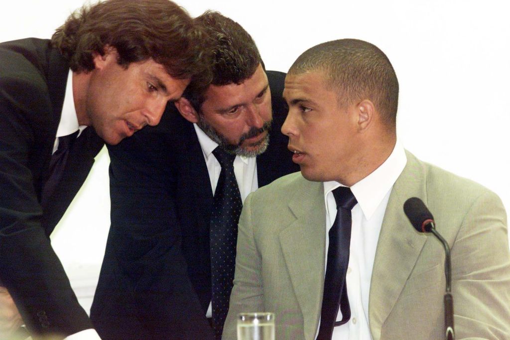 O jogador de futebol Ronaldo Nazário conversa com seus advogados, Rodrigo Paiva (esq.) e Fabiano Gerbassi (centro) durante depoimento, no Congresso, em Brasília, em janeiro de 2001.