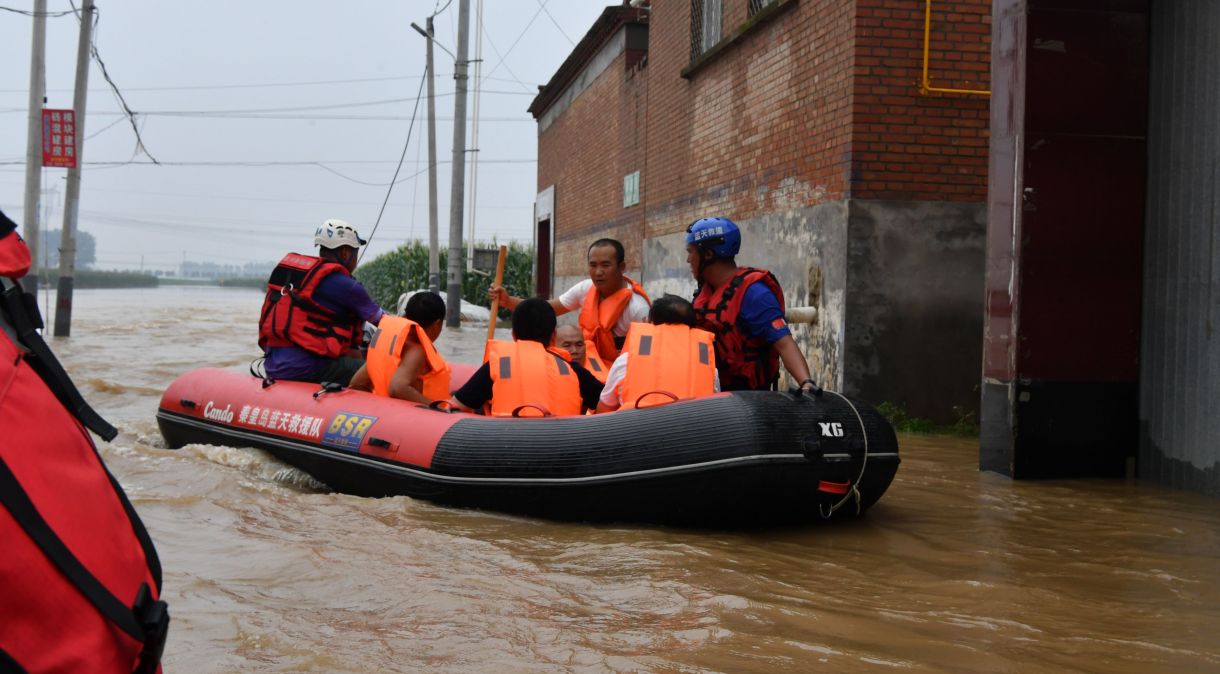 Equipes de resgate usam barco retirar pessoas presas pelas inundações após dias de chuvas trazidas pelo tufão Doksuri na China