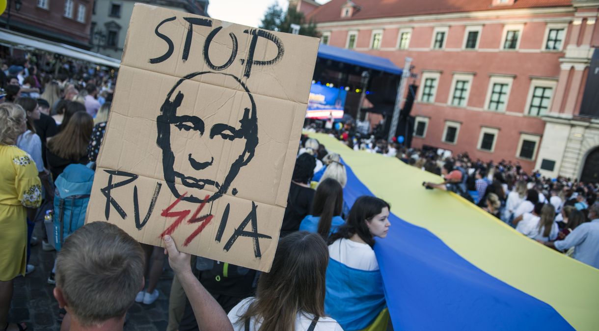 Manifestantes ucranianos seguram cartazes anti-guerra e anti-russos durante o comício, marcando o Dia da Independência da Ucrânia