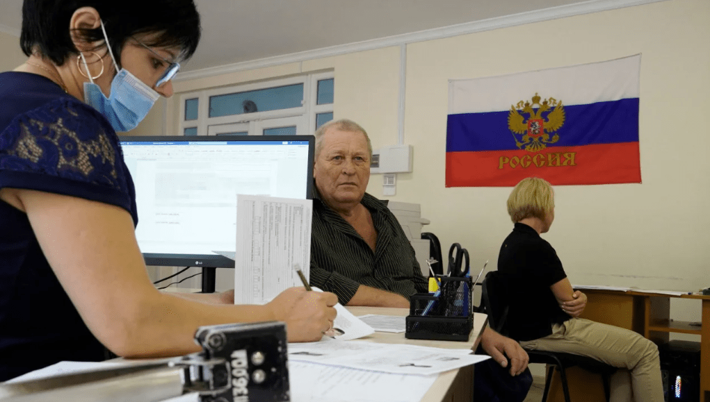 Um homem preenche documento para solicitar um novo passaporte russo em um centro em Melitopol, na região de Zaporizhzhia, em 3 de agosto de 2022, em meio à ação militar russa em andamento na Ucrânia.