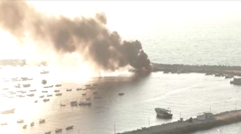 Um barco de pesca foi registrado em chamas no porto, enquanto mais foguetes continuavam a cair na água ao seu redor