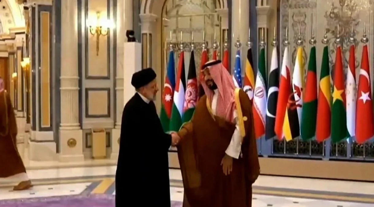 O presidente iraniano, Ebrahim Raisi, à esquerda, aperta a mão do príncipe herdeiro saudita, Mohammed bin Salman