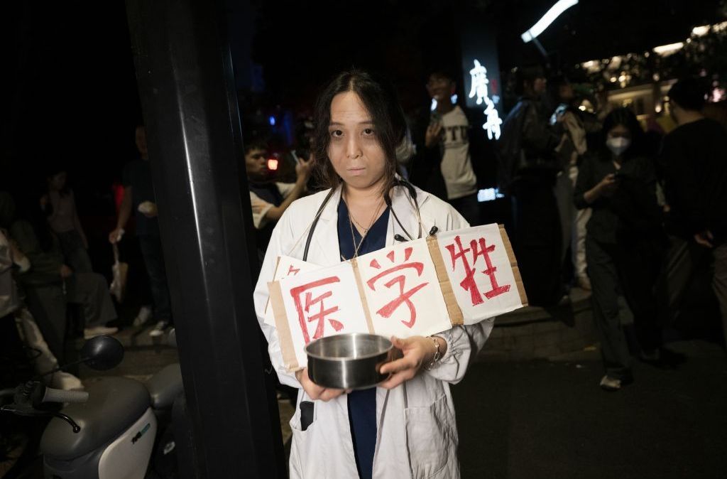 Jovem chinesa se fantasia de estudante de medicina necessitada em Halloween em Xangai