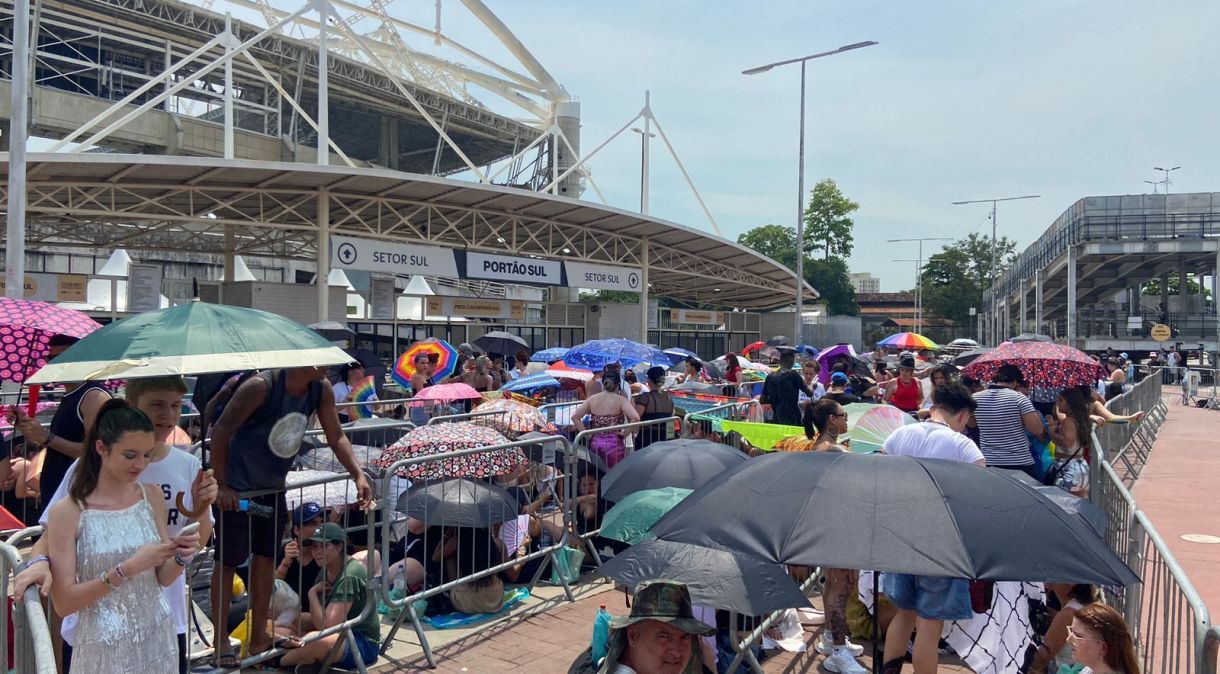 Fãs da Taylor Swift apelam para guarda-chuvas para se proteger do sol na fila do show no Rio de Janeiro, em 17 de novembro