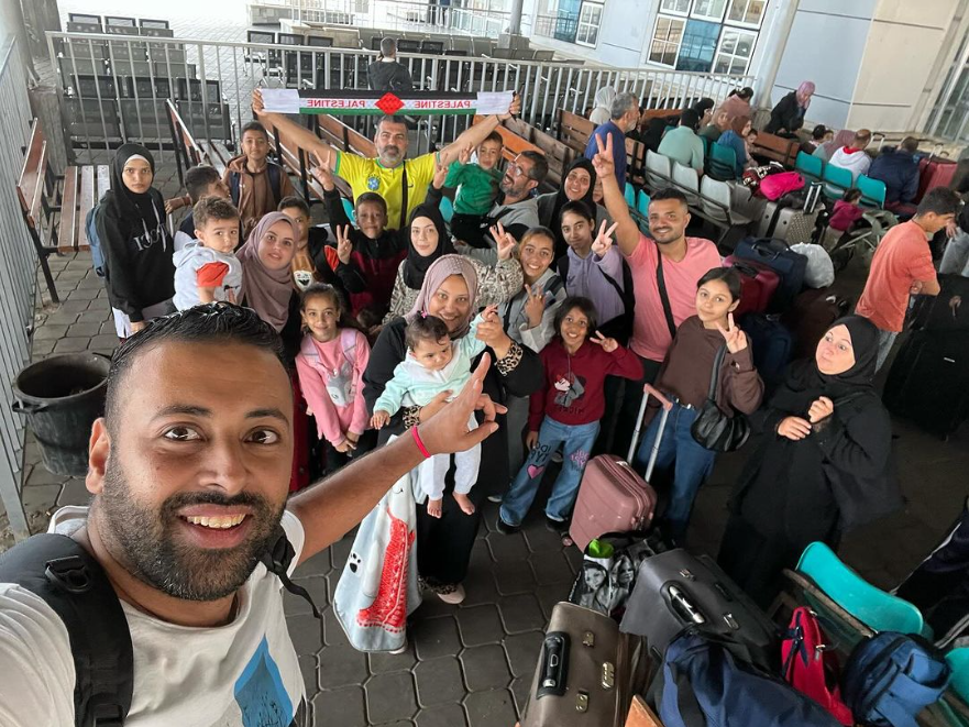 Hasan Rabee com grupo de brasileiros e familiares na fronteira com o Egito na manhã deste domingo (12)