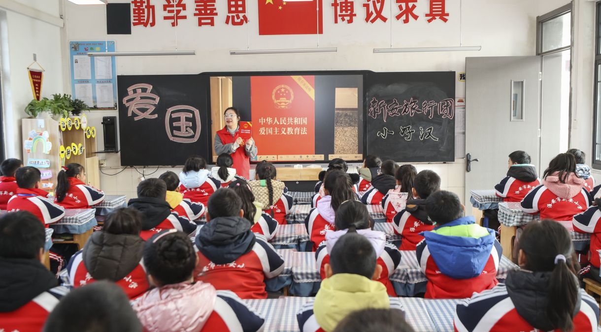 Uma advogada voluntária explica o a Lei de Educação Patriótica da República Popular da China para alunos do ensino primário em Huai'an, China