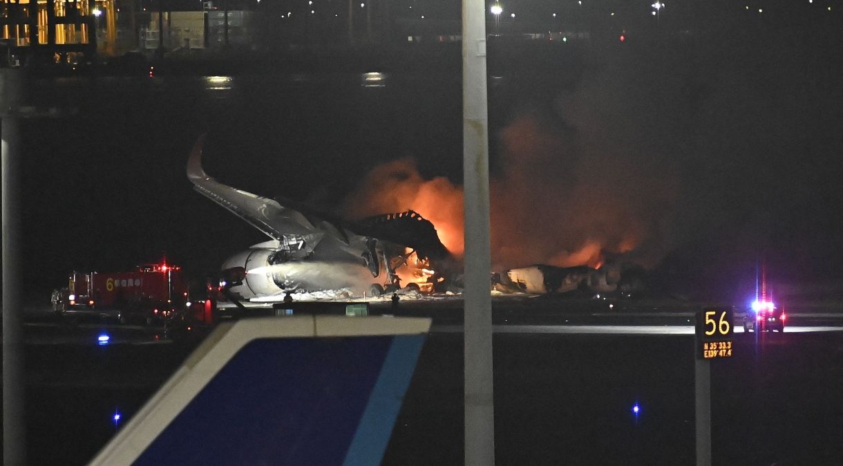 Bombeiros intervêm nos aviões em chamas depois que um avião da Japan Airlines e uma aeronave da Guarda Costeira do Japão colidiram no aeroporto de Tóquio