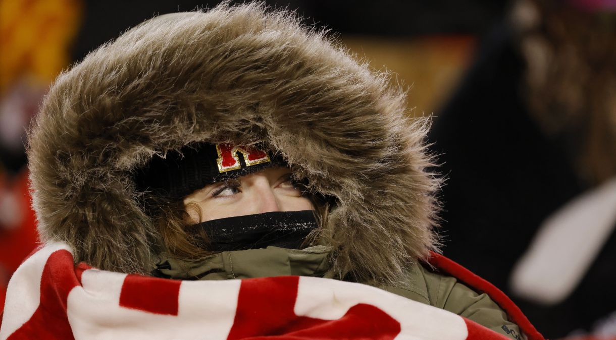 Torcedora do Kansas City Chiefs tenta se proteger do frio em jogo da NFL