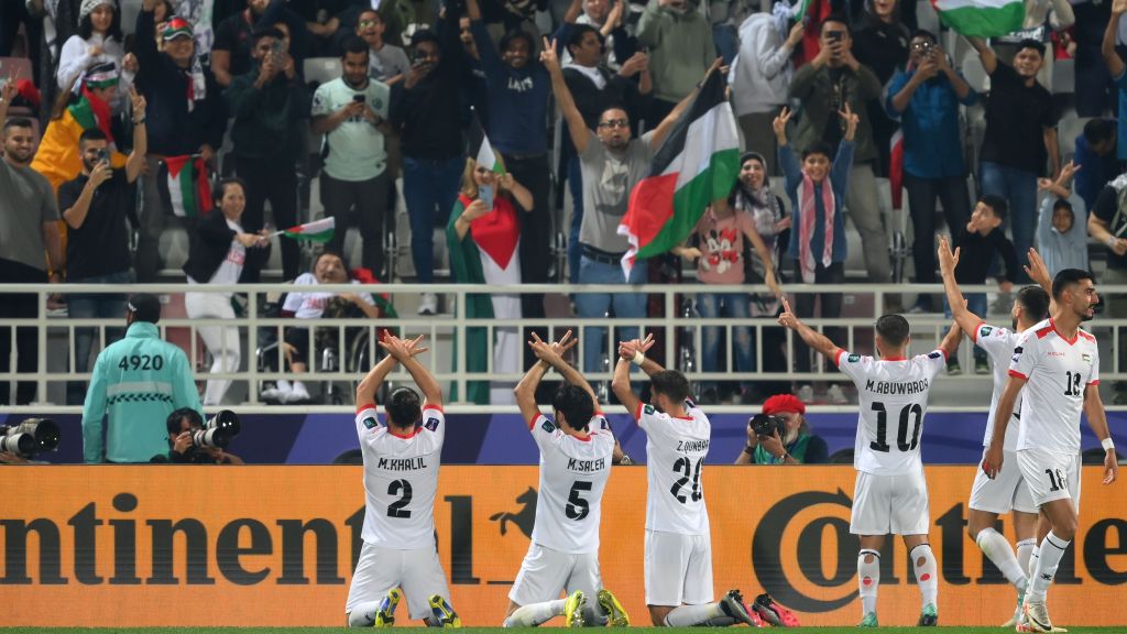 Jogadores da Palestina comemoram a vitória sobre Hong Konh com a torcida presente ao estádio no Catar