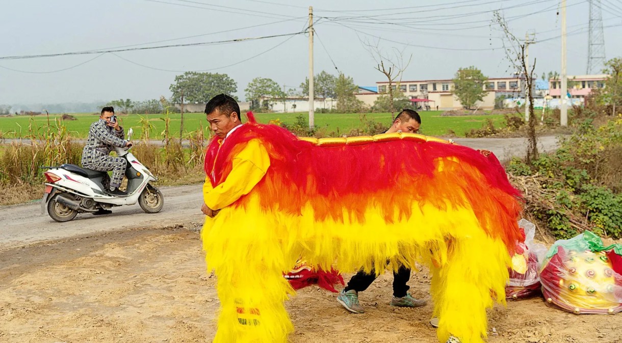 Homens vestem fantasia de "dança do leão" para comemorações do Shehuo em Huozhuang, vilarejo da província chinesa de Henan