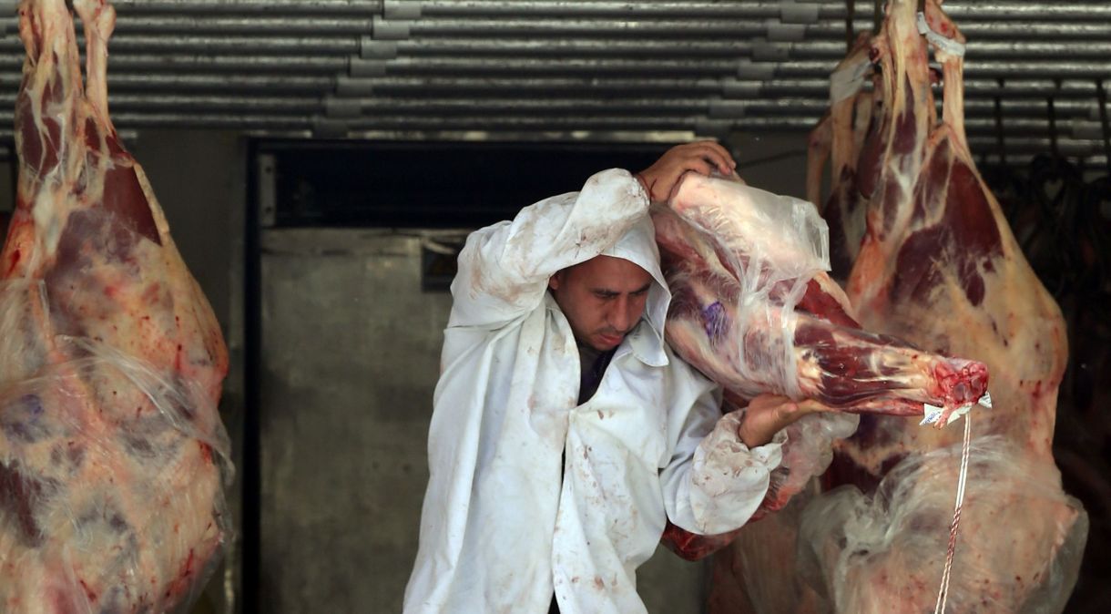 Açougueiro descarrega carne de um caminhão do lado de fora de um açougue em São Paulo, Brasil