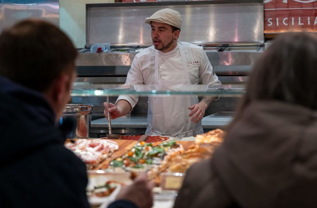 Um homem faz pizza em restaurante no Chelsea Market, em Manhattan, em 2 de fevereiro de 2024, na cidade de Nova York
