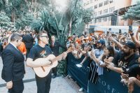 Vocalista do Blink-182 toca violão para fãs em frente a hotel em SP; assista