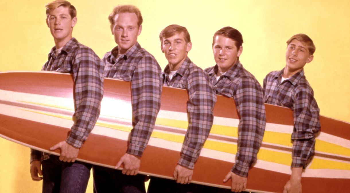 Os Beach Boys posam para um retrato com uma prancha de surf em 1962