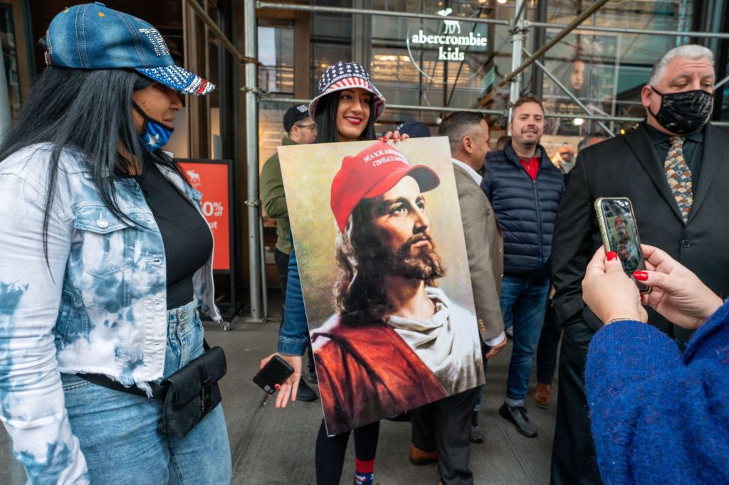 Pessoa segura uma pintura de Jesus usando um boné "Make America Great Again", em Nova York.