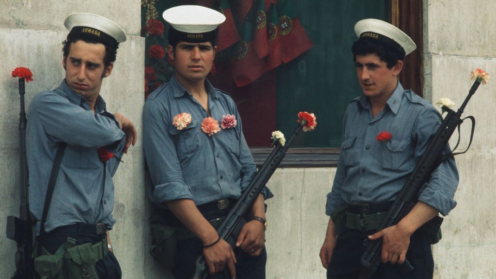 Soldados portugueses com cravos nos uniformes e nos canos das armas montam guarda em Lisboa, em 29 de abril de 1974