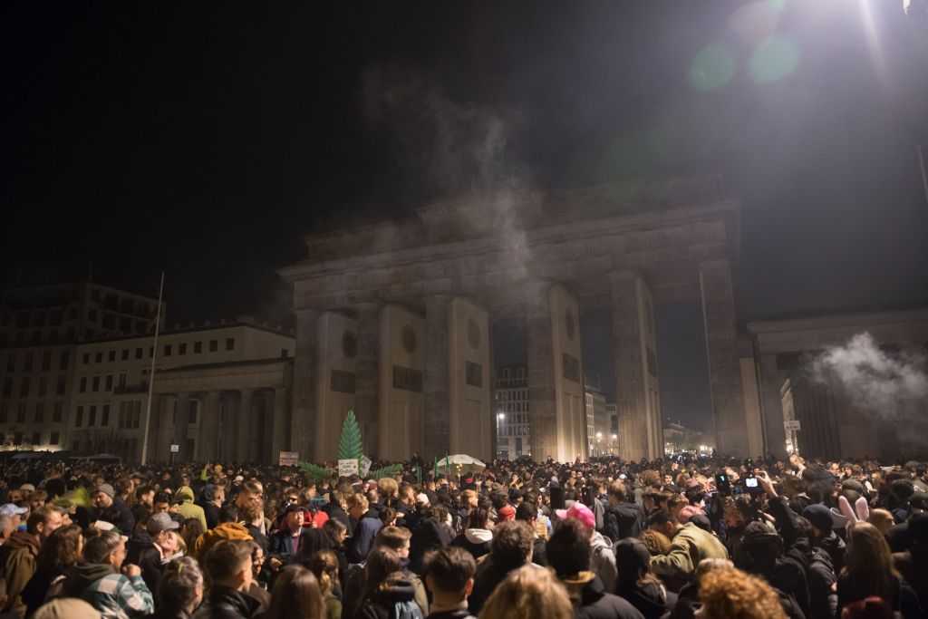 Entusiastas da cannabis fumam baseados legalmente no Portão de Brandemburgo, em Berlim, pouco após a meia-noite de 1º de abril de 2024, quando entrou em vigor a legalização parcial da maconha na Alemanha.