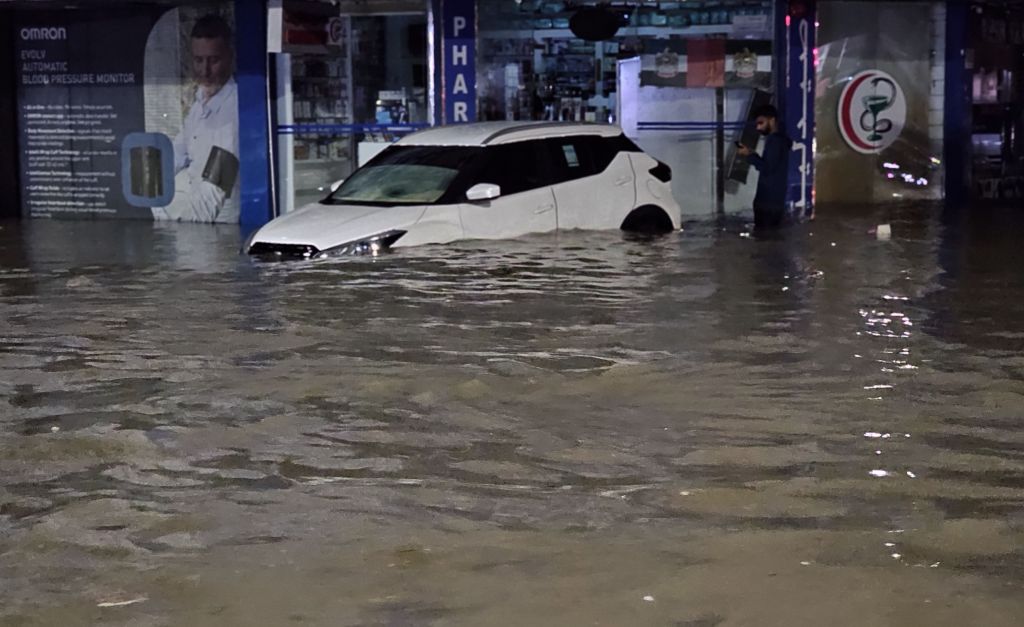 Carros atravessam estradas inundadas devido a fortes chuvas, já que as condições climáticas adversas afetam negativamente a vida diária em Dubai, Emirados Árabes Unidos, em 15 de abril de 2024.