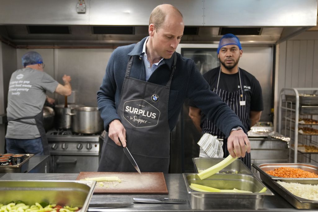 Príncipe William corta aipo enquanto ajuda chef a fazer molho à bolonhesa em visita a instituição de caridade, em Surrey, Inglaterra, em 18 de abril de 2024.