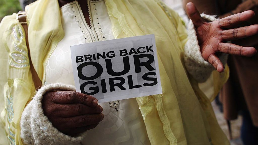 Mulher segura uma placa que diz 'Traga de volta nossas meninas' durante um protesto em frente à Nigeria House em 9 de maio de 2014 em Londres, Inglaterra, ano em que 276 estudantes foram raptadas de um na cidade de Chibok, no nordeste do estado de Borno, na Nigéria