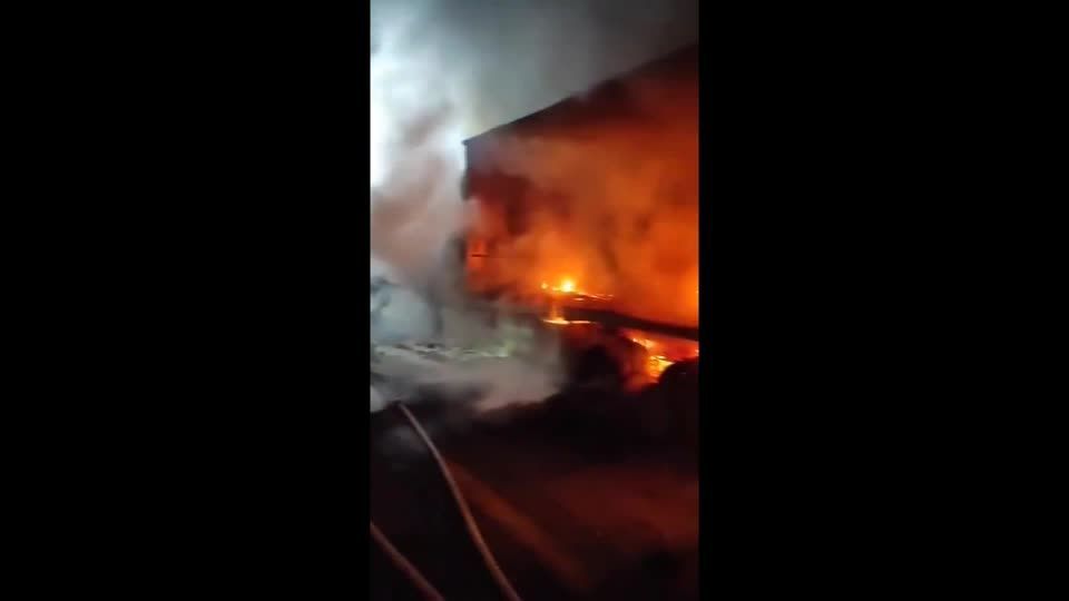 Bombeiros trabalham para extinguir os caminhões em chamas perto de um posto de controle, a oeste de Hebron.