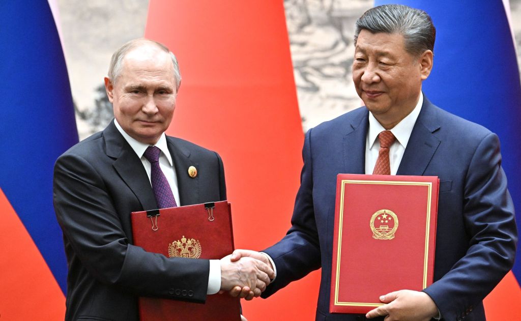 Presidente russo Vladimir Putin e o líder chinês Xi Jinping trocam documentos durante cerimônia em Pequim, China, em 16 de maio de 2024.