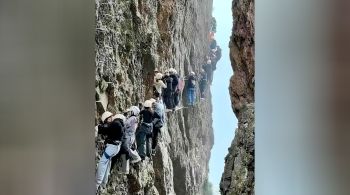 Grupos de viajantes que escalavam a montanha Yandang, no leste da China, ficaram presos no meio de um penhasco, agarrados a uma corda