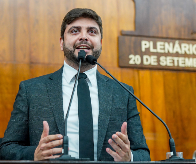 Deputado estadual Felipe Camozzato discursa no plenário. Veste terno cinza e gravata preta. É branco e tem barba e cabelos castanhos. 