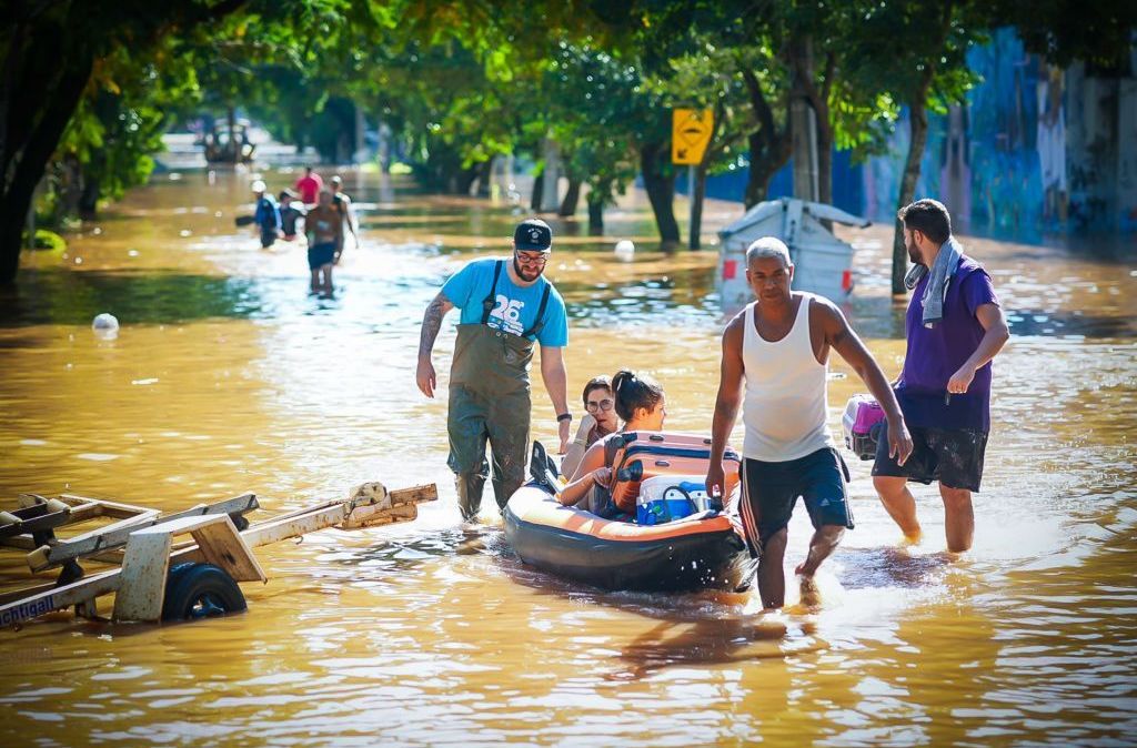 Pessoas caminham pelas ruas inundadas enquanto os esforços de resgate continuam no bairro Menino Deus em 7 de maio de 2024 em Porto Alegre, Brasil.