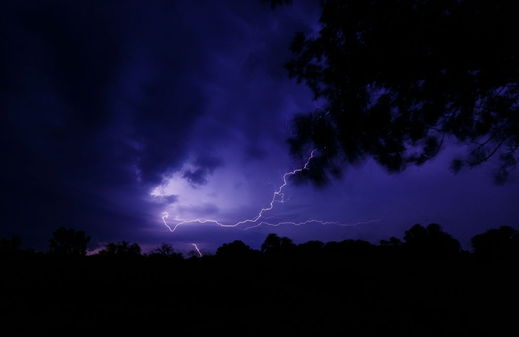 Raio em meio a nuvens de céu noturno