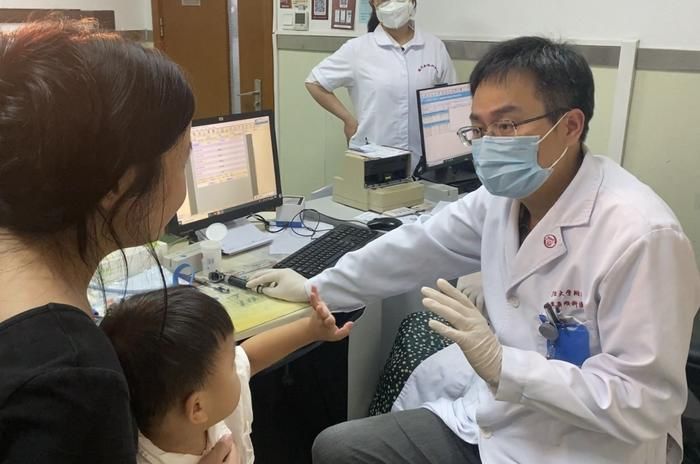 Yilai Shu se comunica com um paciente participante do estudo no Eye & ENT Hospital da Universidade Fudan em Xangai, China.