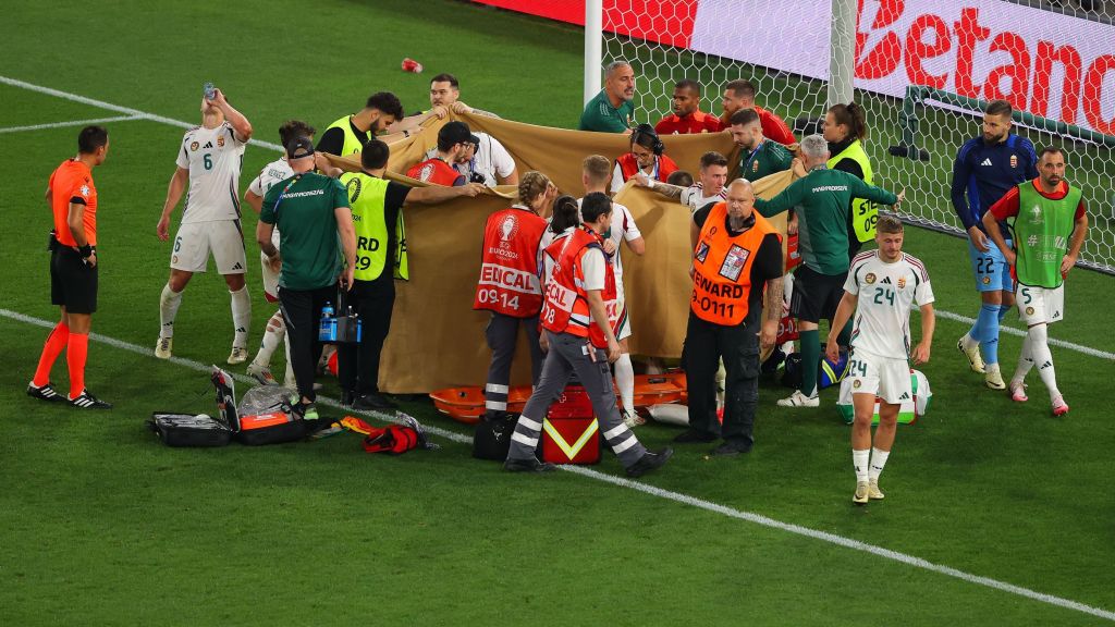 Barnabás Varga é atendido no gramado enquanto panos são levantados para que o público não veja a cena