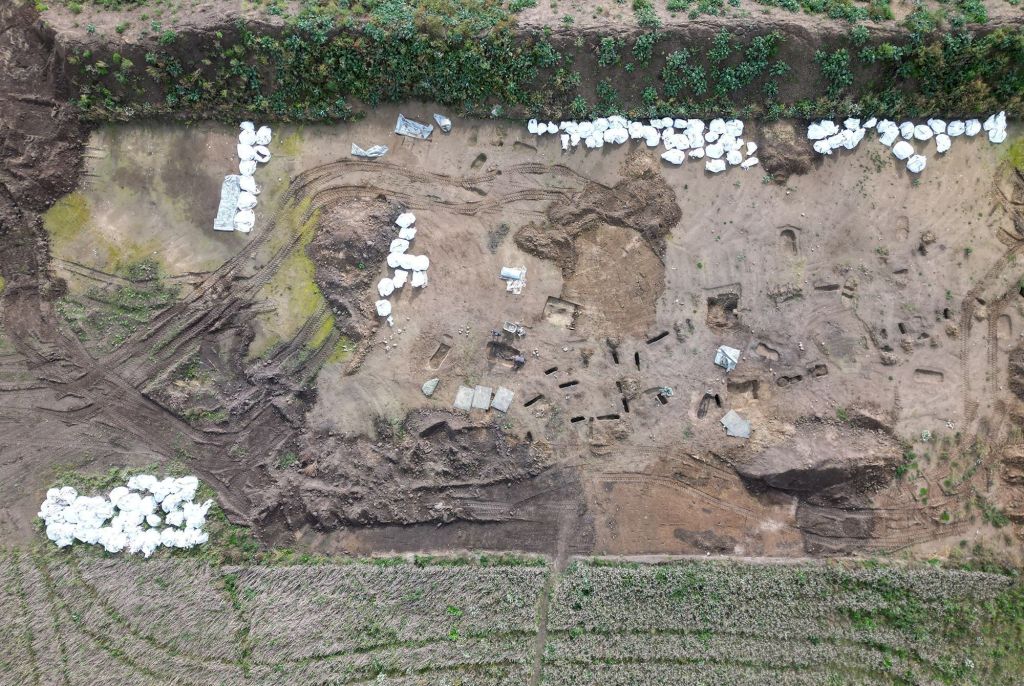 Vista aérea mostra arqueólogos trabalhando em escavações no local de sepultamento da era Viking encontrado no vilarejo de Asum, na Dinamarca