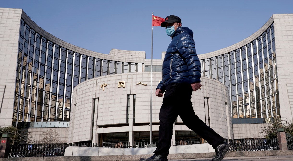 Homem caminha de máscara em frente ao banco central da China, em Pequim