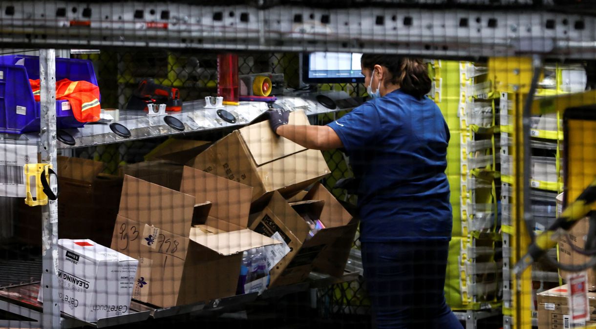 Trabalhadora prepara produtos para transporte em centro de distribuição da Amazon em Robbinsville, EUA