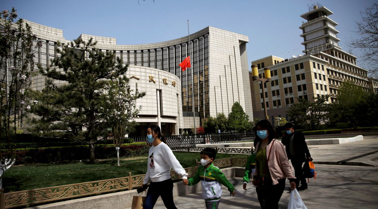 Pessoas com máscaras passam pela sede do banco central chinês