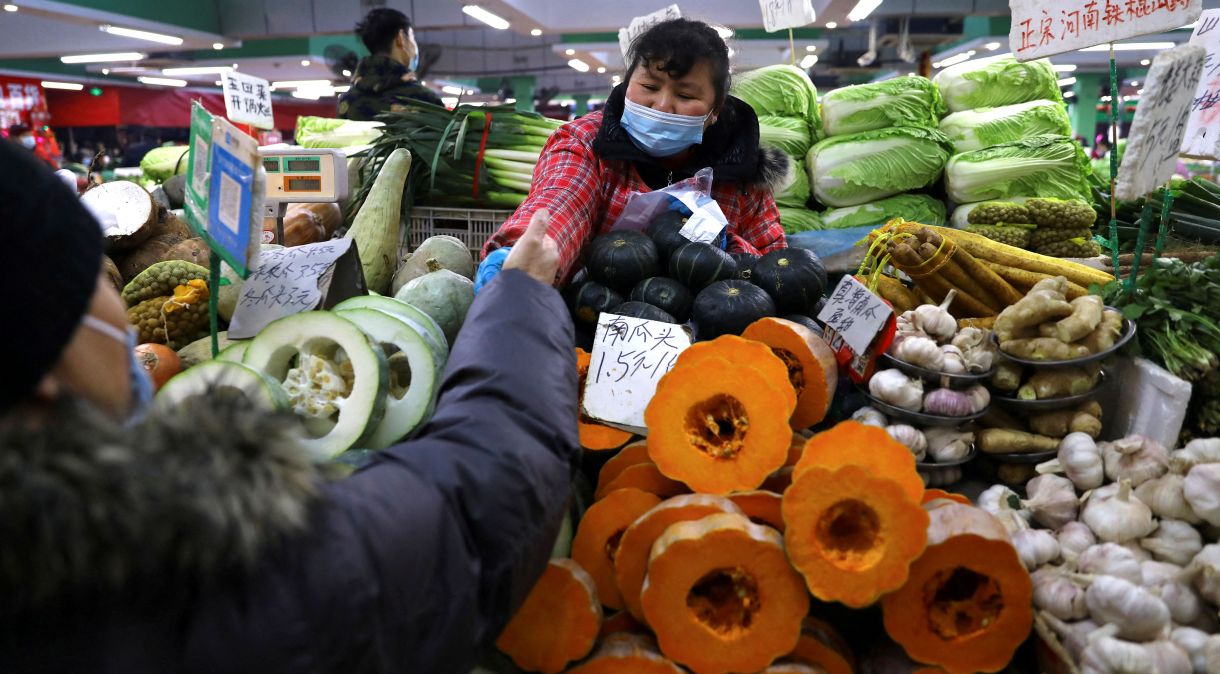 Consumidora compra verduras em mercado em Pequim