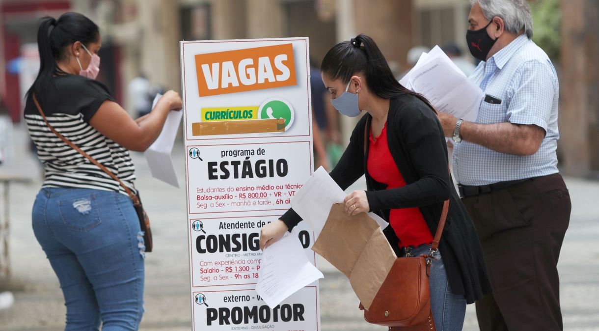 Pessoas buscam emprego em listagem de vagas no centro de São Paulo