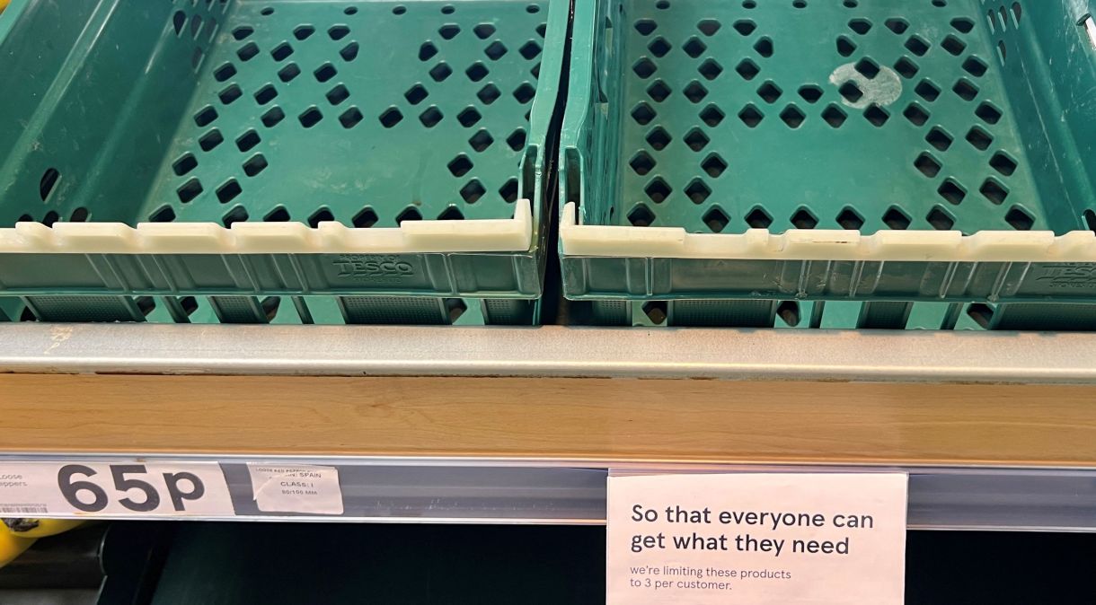 Um aviso limitando os clientes a três itens cada é vistao ao lado de caixas vazias na seção de tomates e pimentões de um supermercado Tesco, em Manchester, Reino Unido