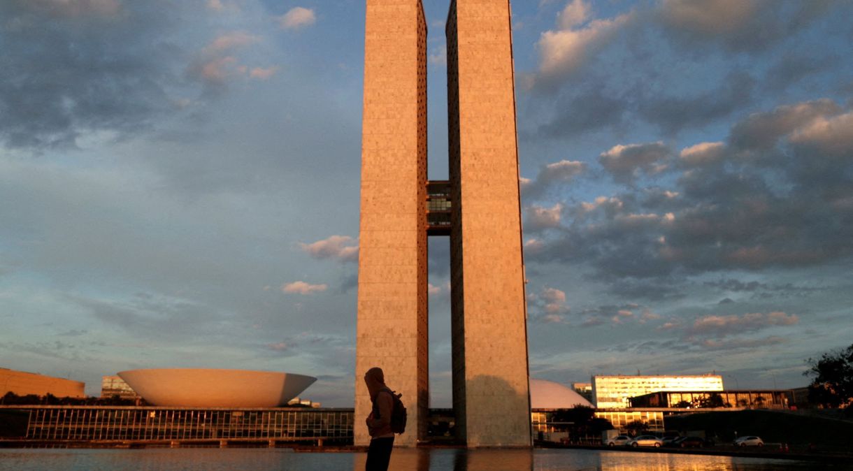 Homem caminha próximo ao prédio do Congresso Nacional, em Brasília