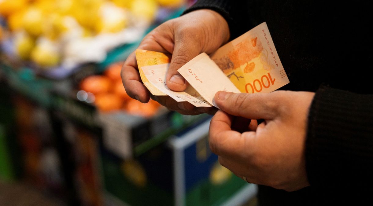 Consumidor conta notas de peso em supermercado de Buenos Aires, na Argentina