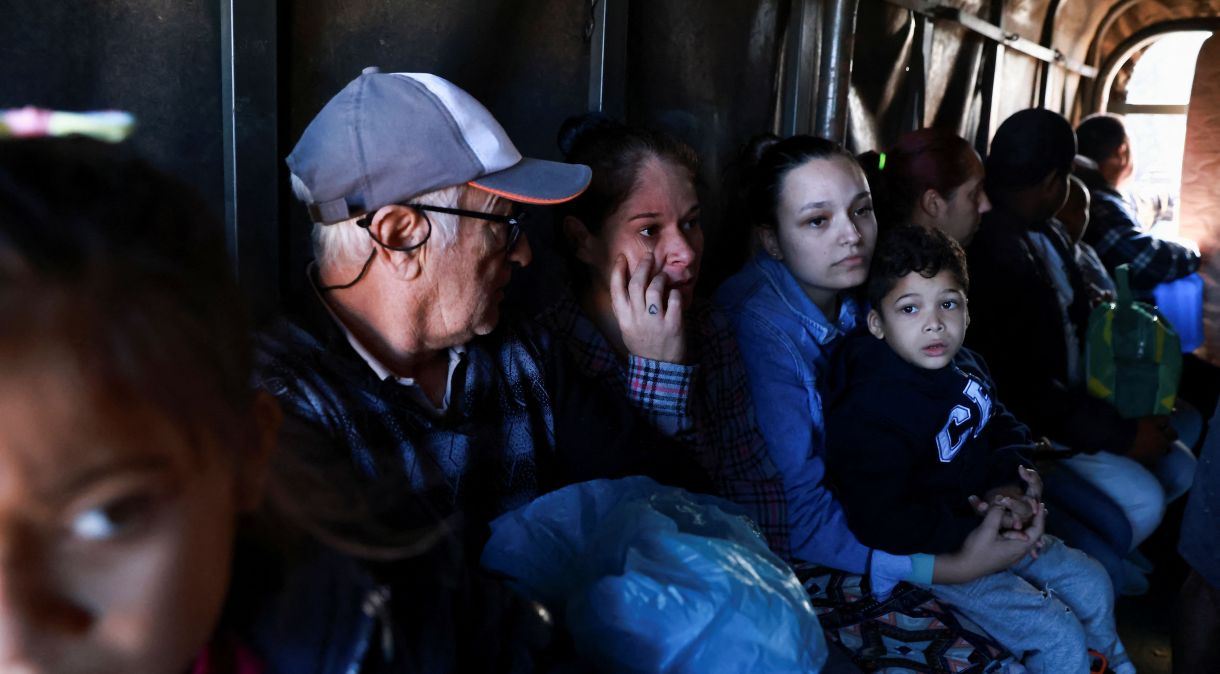 Sobreviventes sentam em caminhão enquanto são retirados em Porto Alegre, no Rio Grande do Sul