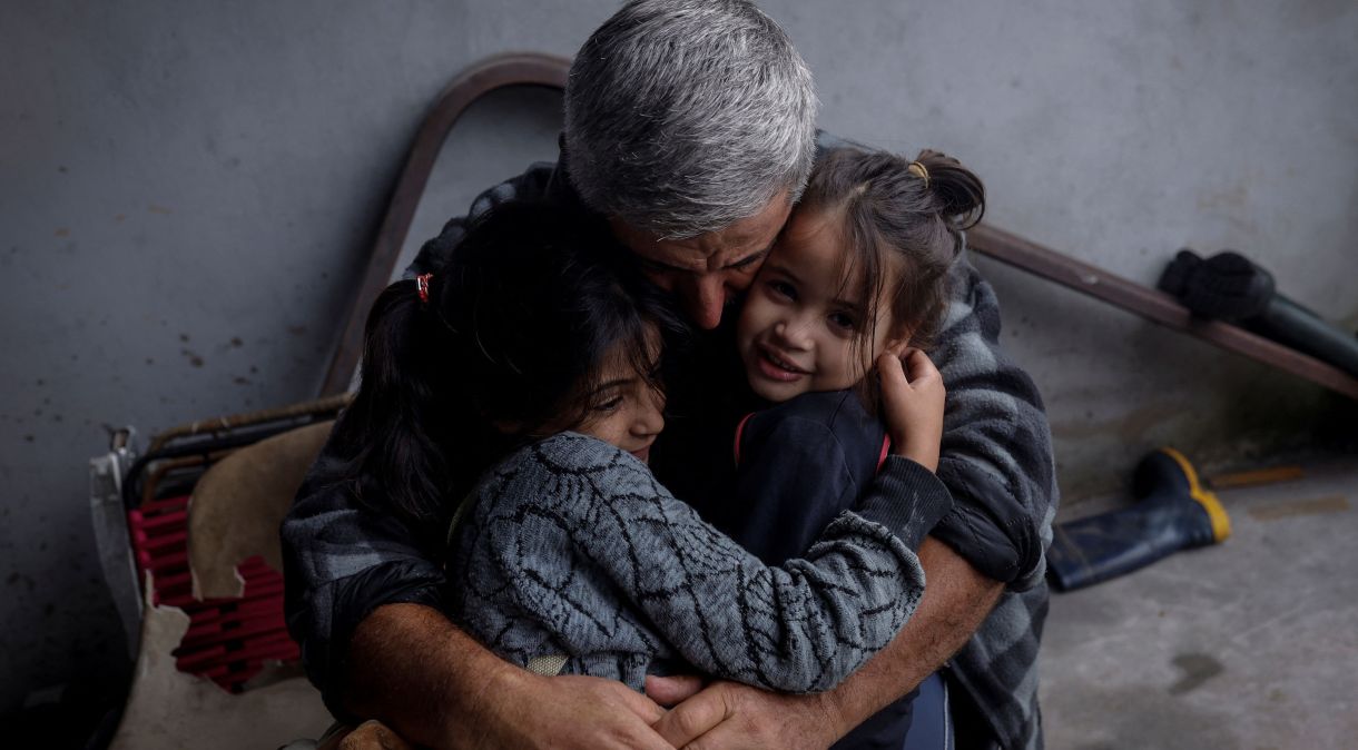Avô abraça netas em armazém de Eldorado do Sul, no Rio Grande do Sul