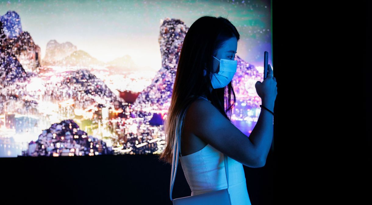 Visitante tira fotos em frente a instalação artística em vídeo, em Hong Kong, que será convertida em NFTs e leiloada online pela Sotheby's