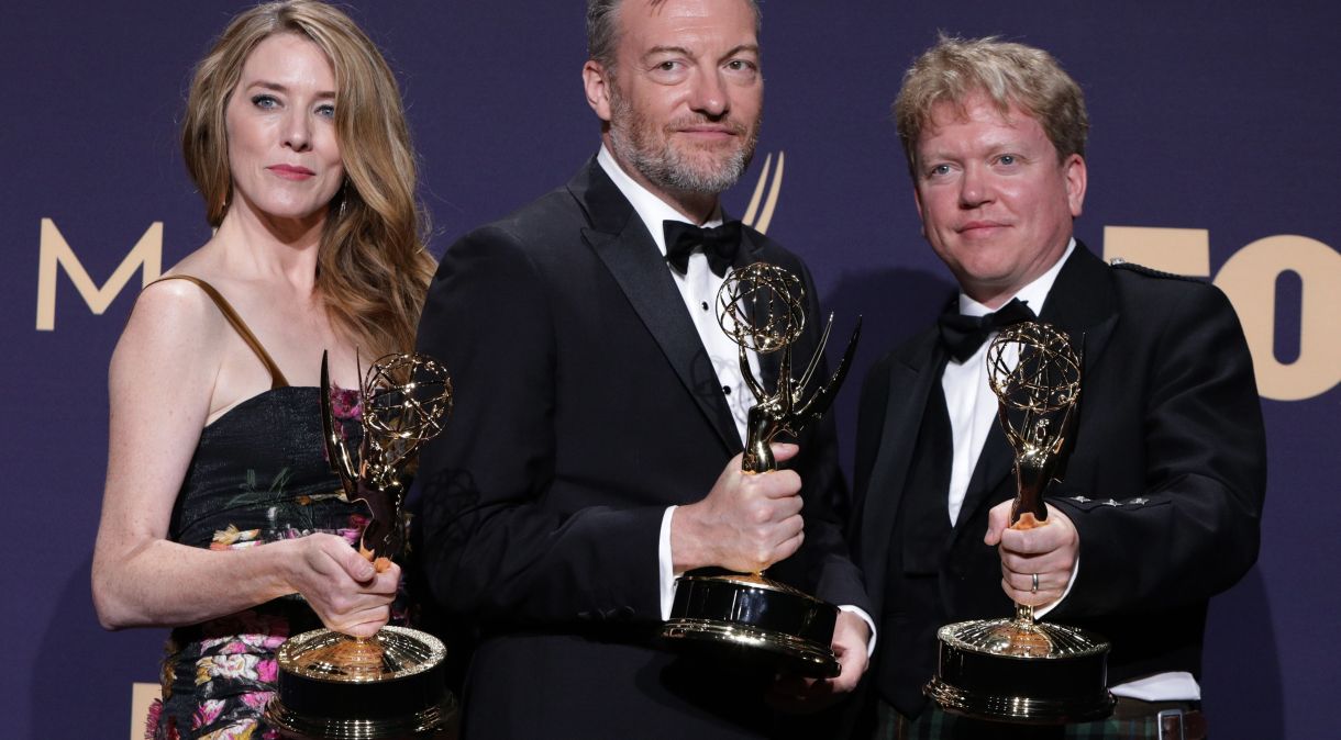 Annabel Jones, Charlie Brooker e Russel McLean posam nos bastidores do Emmy com prêmios recebidos por "Black Mirror"