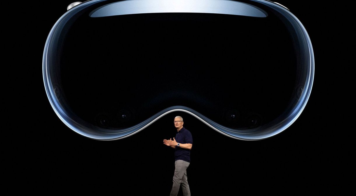 CEO da Apple, Tim Cook, fala sob uma imagem do Apple Vision Pro no Apple Park em Cupertino, Califórnia, EUA