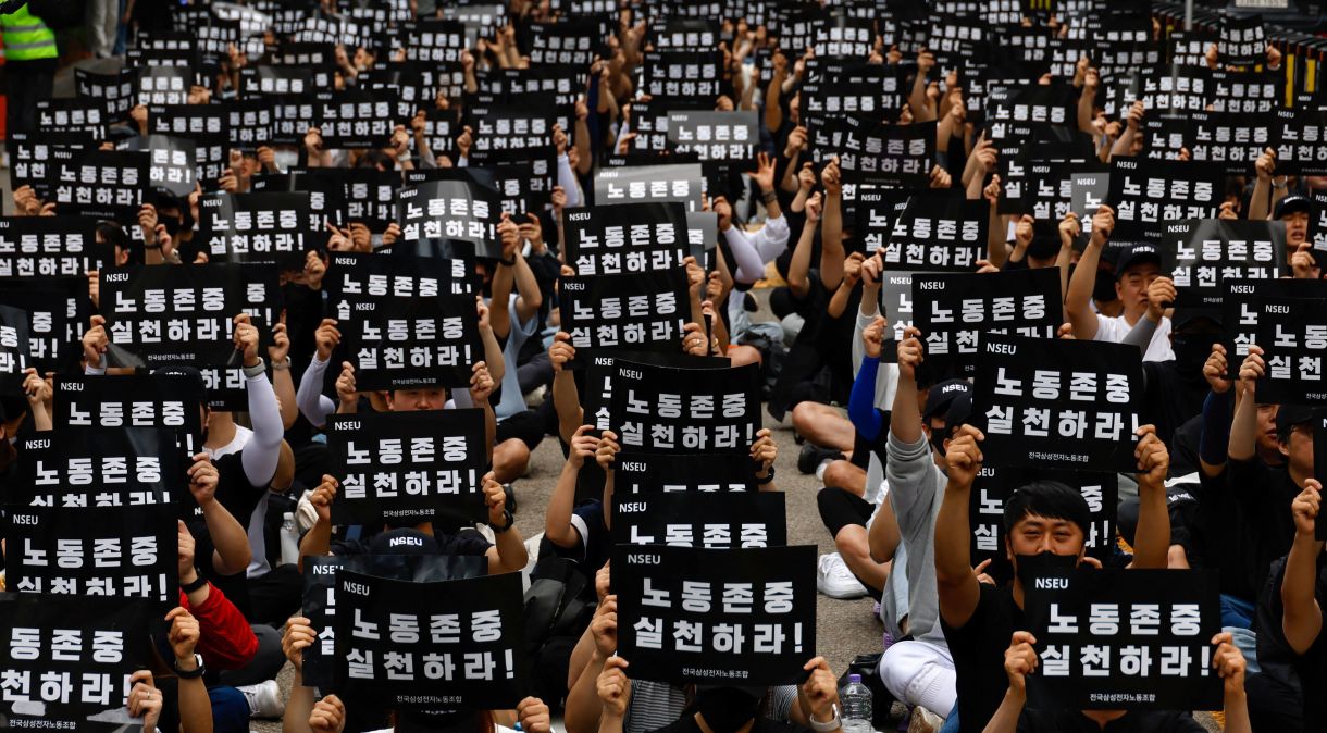Membros do sindicato National Samsung Electronics Union (NSEU) seguram faixas com a frase "Respeite o trabalho" em frente ao edifício Samsung Electronics Seocho, em Seul, Coreia do Sul
