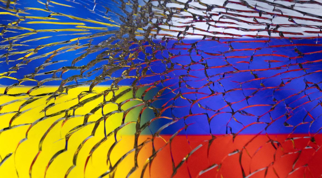 Bandeiras da Ucrânia e da Rússia vistas por meio de vidro quebrado em foto de ilustração