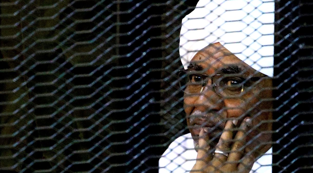 Ex-presidente do Sudão Omar Hassan al-Bashir senta em cela dentro de tribunal, em Cartum, Sudão